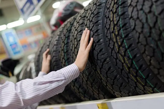 man choosing a car tyre in a store